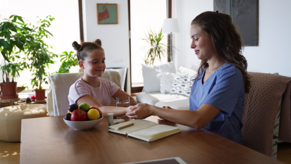 Nurse checking girl's blood glucose level using a fingerstick glucose meter. Endocrinologist waiting for results from his blood test.