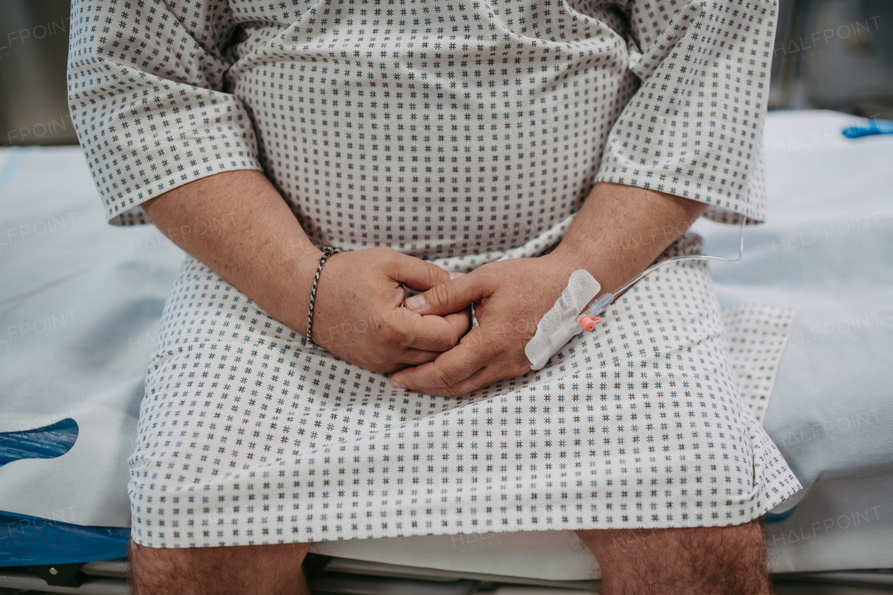 Rear view of overweight patient in hospital gown waiting for the medical examination, test results in hospital, feeling anxious, worried and scared.