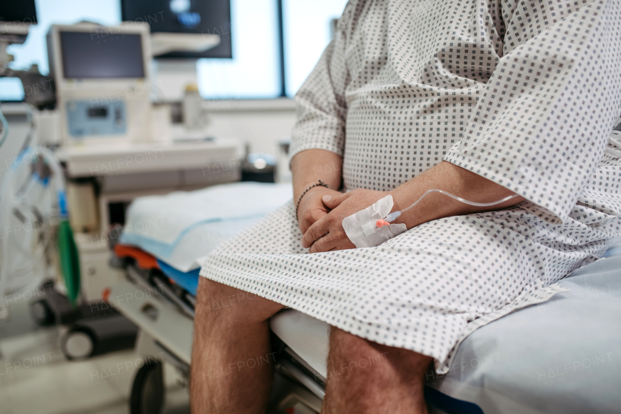 Close up of overweight patient in hospital gown waiting for the medical examination, test results in hospital, feeling anxious, worried. Patient feeling dizzy, have vertigo and intense pain.