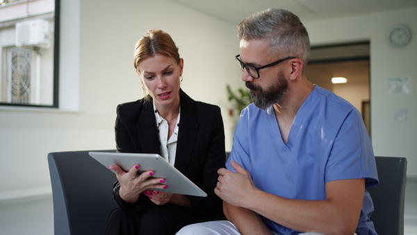 Pharmaceutical sales representative talking with doctor in medical building. Ambitious female hospital director consulting with healtcare staff. Woman business leader.