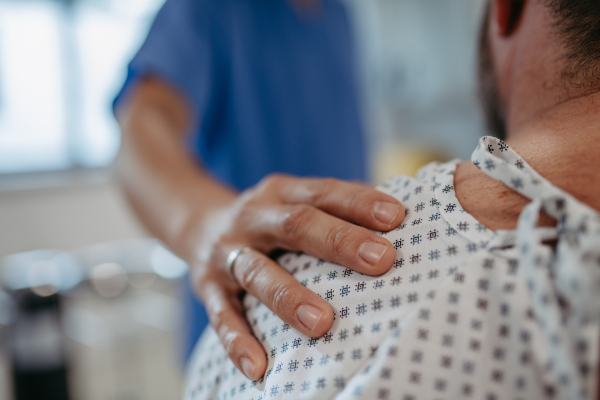 Close up of supportive doctor soothing worried overweight patient, discussing test result in emergency room. Illnesses and diseases in middle-aged men's health. Compassionate physician supporting stressed patient. Concept of health risks of overwight and obesity.