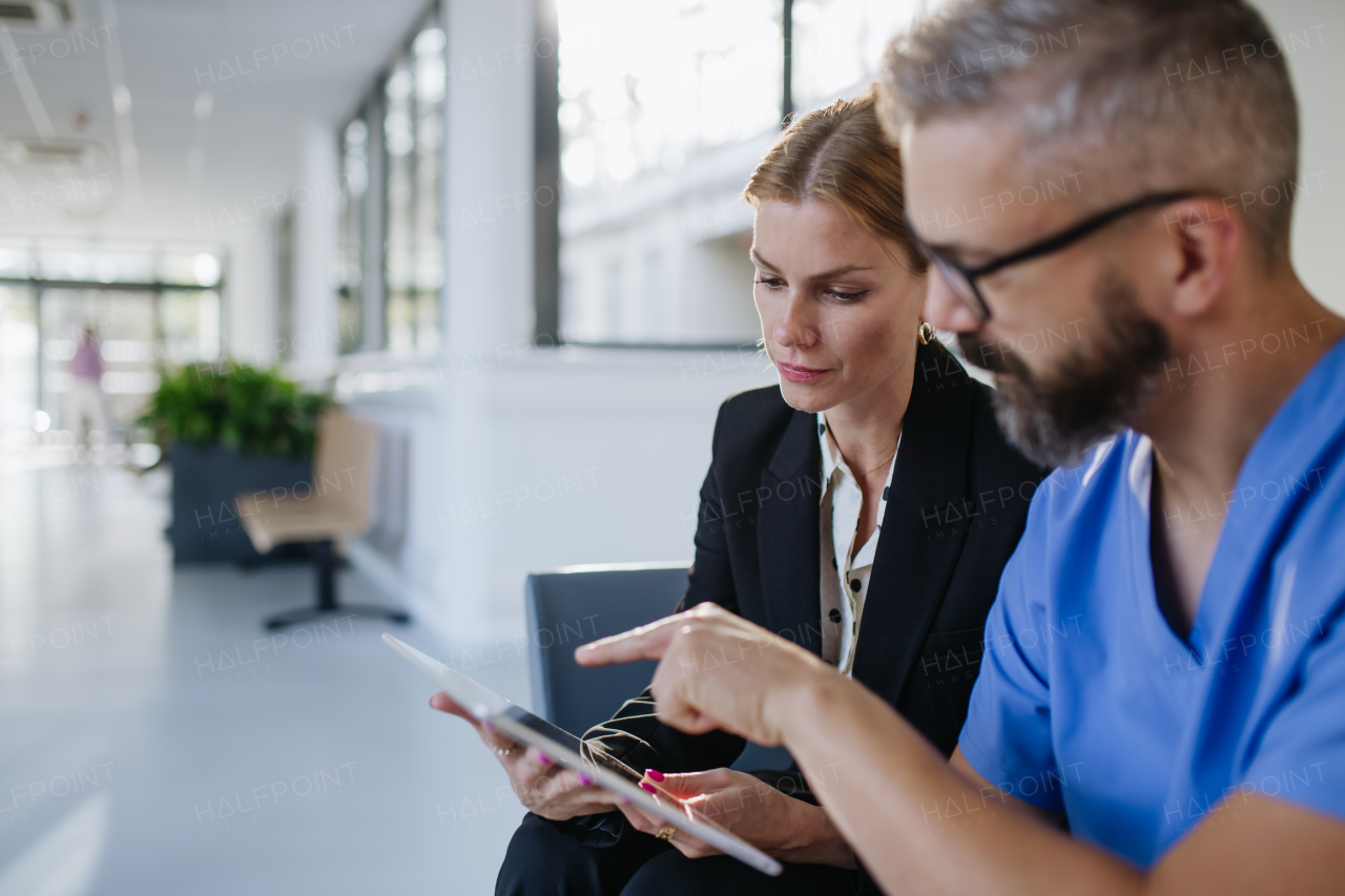 Pharmaceutical sales representative talking with doctor in medical building. Ambitious female sales representative presenting new medication, pills. Woman business leader.