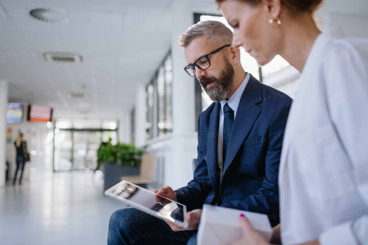 Pharmaceutical sales representative talking with the female doctor in medical building. Hospital director consulting with healthcare staff.