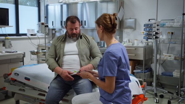 Doctor is injecting insulin into a patient's abdomen using insulin pen. Obese, overweight man is at risk of developing type 2 diabetes. Concept of health risks of overwight and obesity.