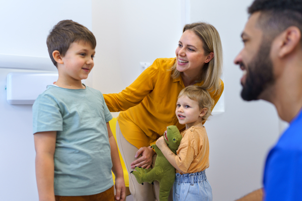 Young multiracial dentist playing with kids at his office in dentist clinic.