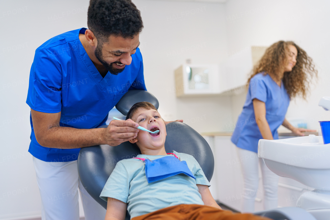 A liitle boy sitting on dentists chair during dentist examination.