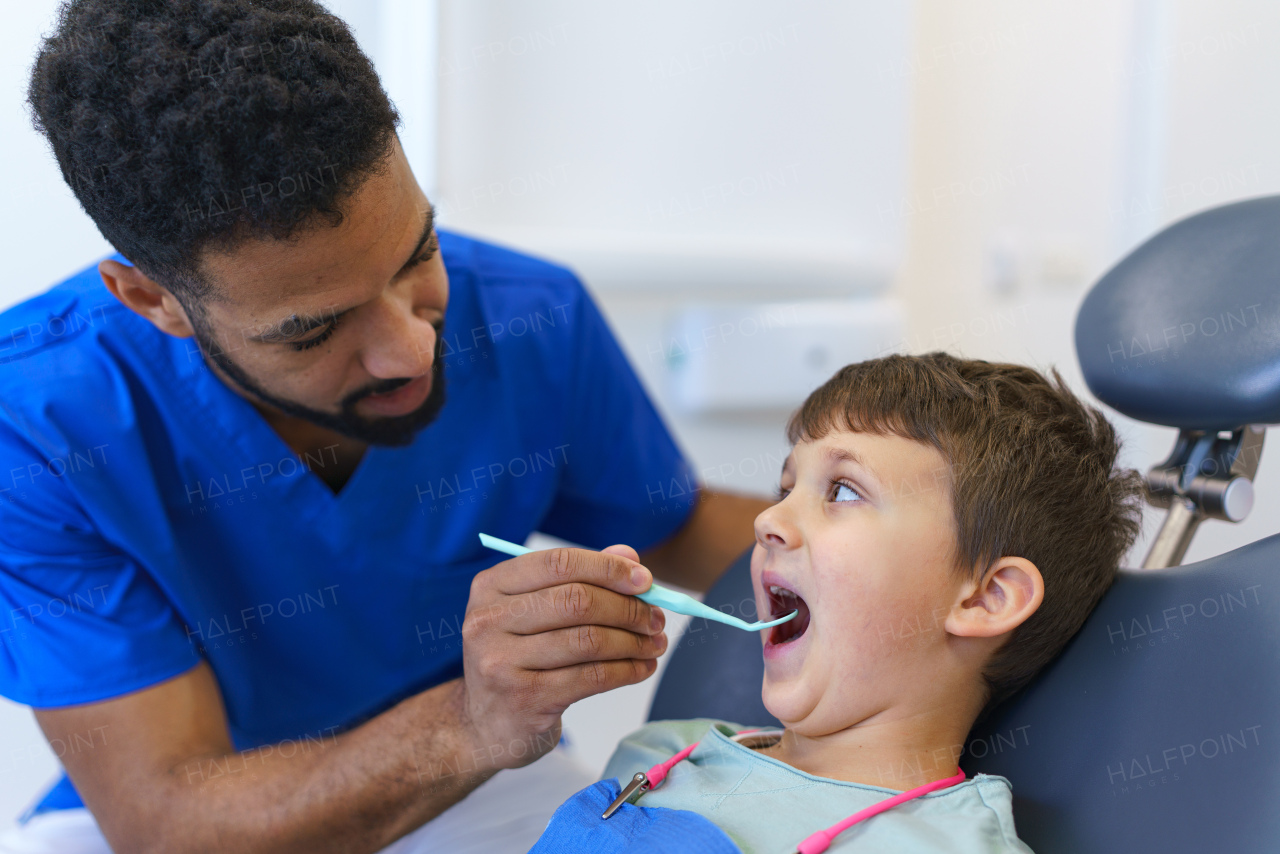 A liitle boy sitting on dentists chair during dentist examination.