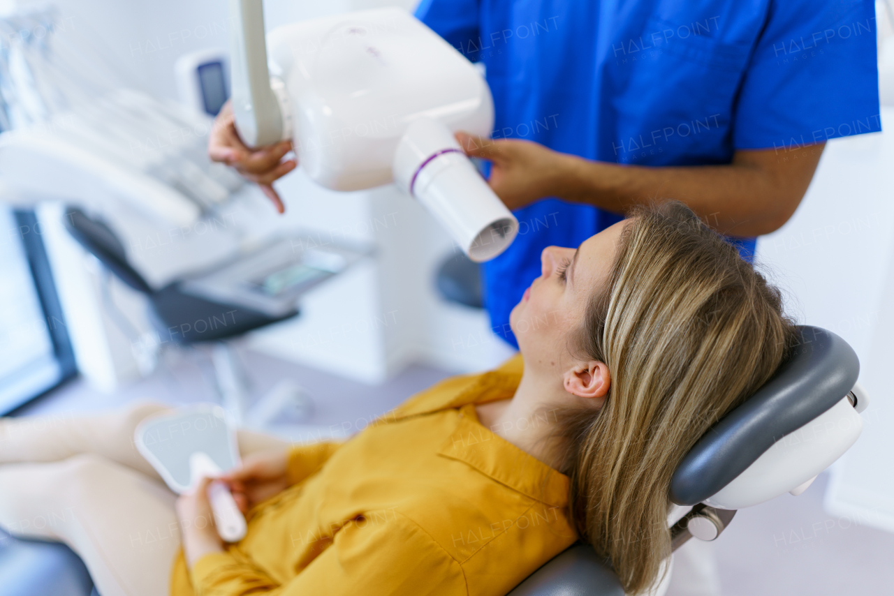 Young woman at dentist, doing x-ray screen of teeth.