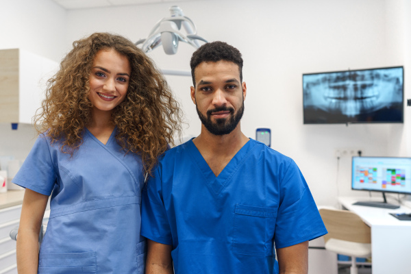 Portrait of young dentist and his nurse at a private dental clinic.