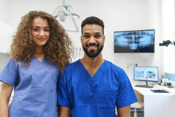 Portrait of young dentist and his nurse at a private dental clinic.