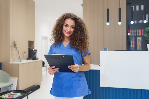 Portrait of dentist nurse posing at reception on a private dental clinic.