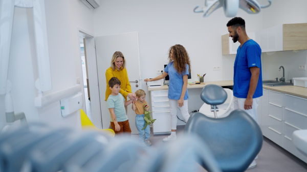 Young mother with two kids entering dentist ambulance.