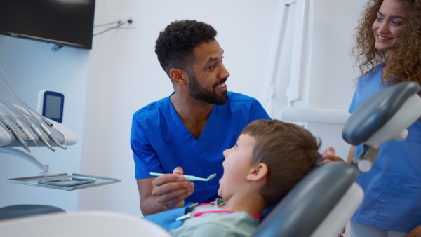 A liitle boy sitting on dentists chair during dentist examination.