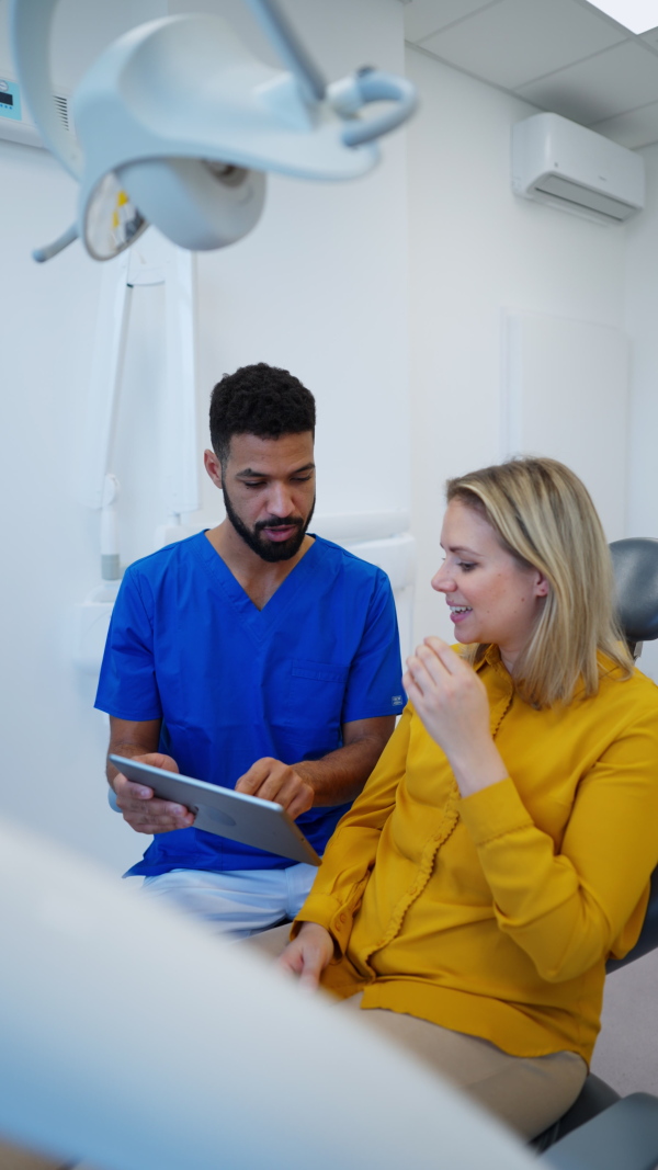 Video of dentist doing a consultation with digital tablet with his patient. Vertical footage.