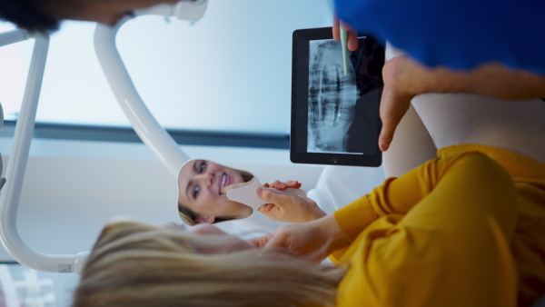 Video of dentist doing a consultation with digital tablet with his patient. Vertical footage.