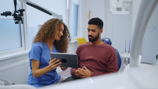 Video of dentist doing a consultation with digital tablet with his patient.