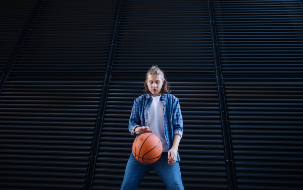 Young man dribbling with a basketball ball,outdoor in city. Youth culture.