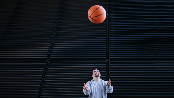 Young man with down syndrom throwing away a basketball ball.