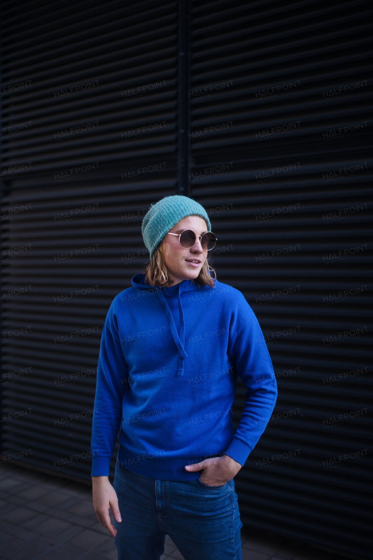 Portrait of young man with cap and sunglasses outdoor in a city. Youth culture.