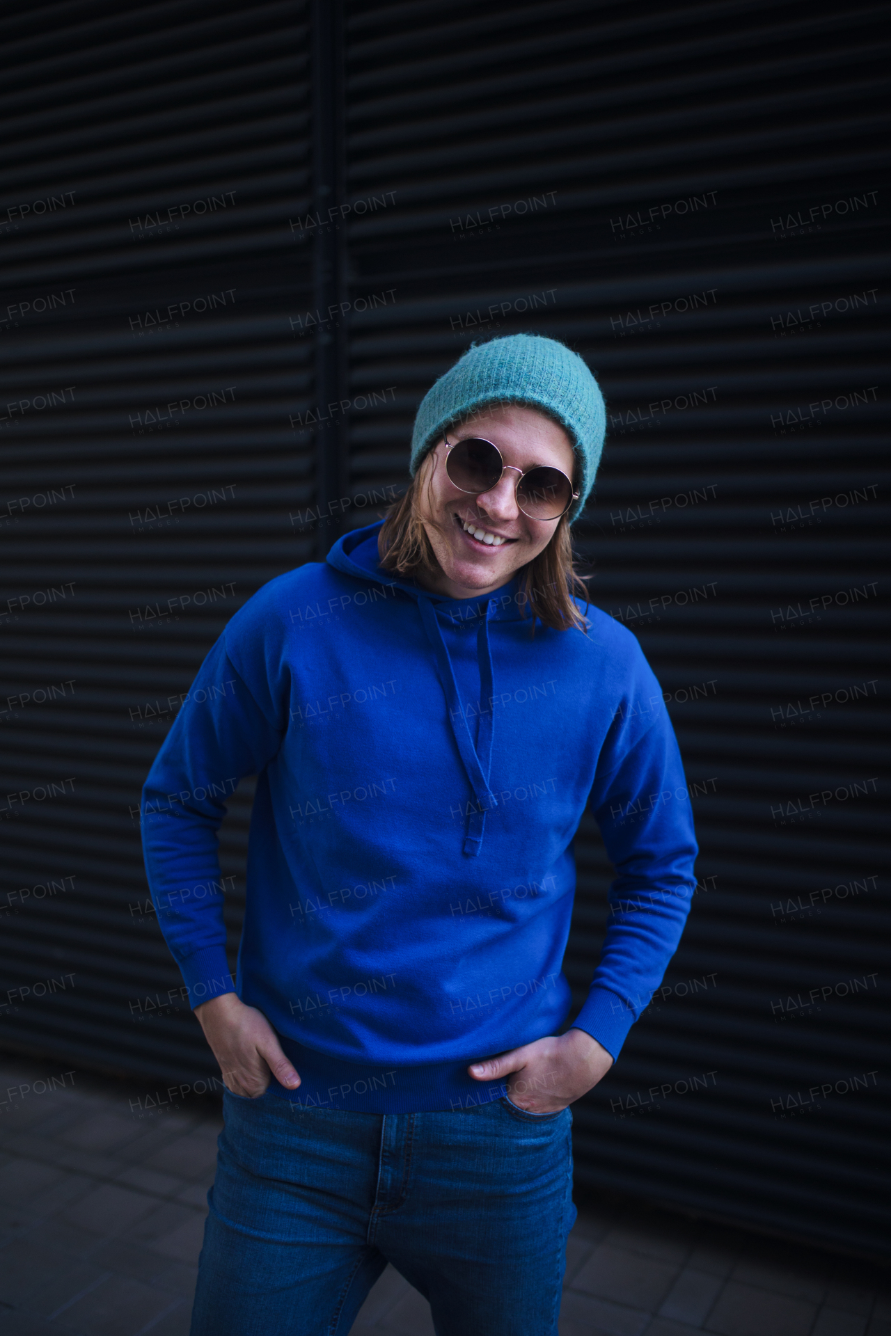 Portrait of young man with cap and sunglasses outdoor in a city. Youth culture.