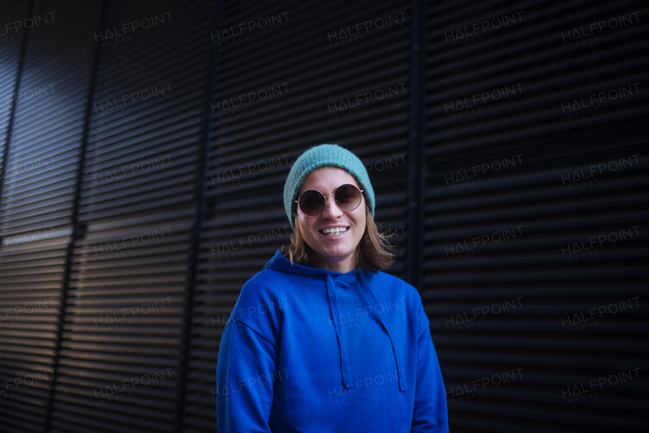 Portrait of young man with cap and sunglasses outdoor in a city. Youth culture.