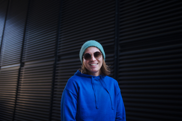 Portrait of young man with cap and sunglasses outdoor in a city. Youth culture.