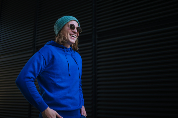 Portrait of young man with cap and sunglasses outdoor in a city. Youth culture.