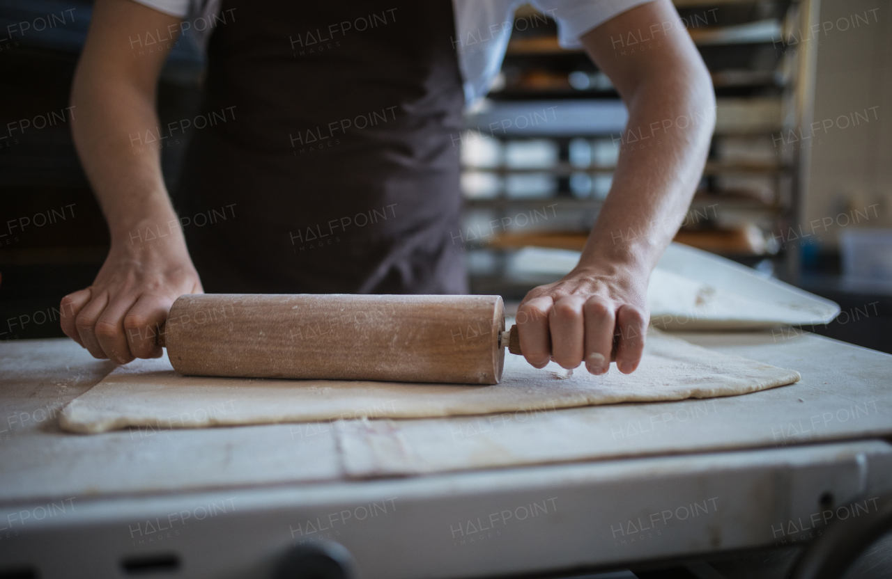 Close-up of young baker preparing pastries in a bakery.