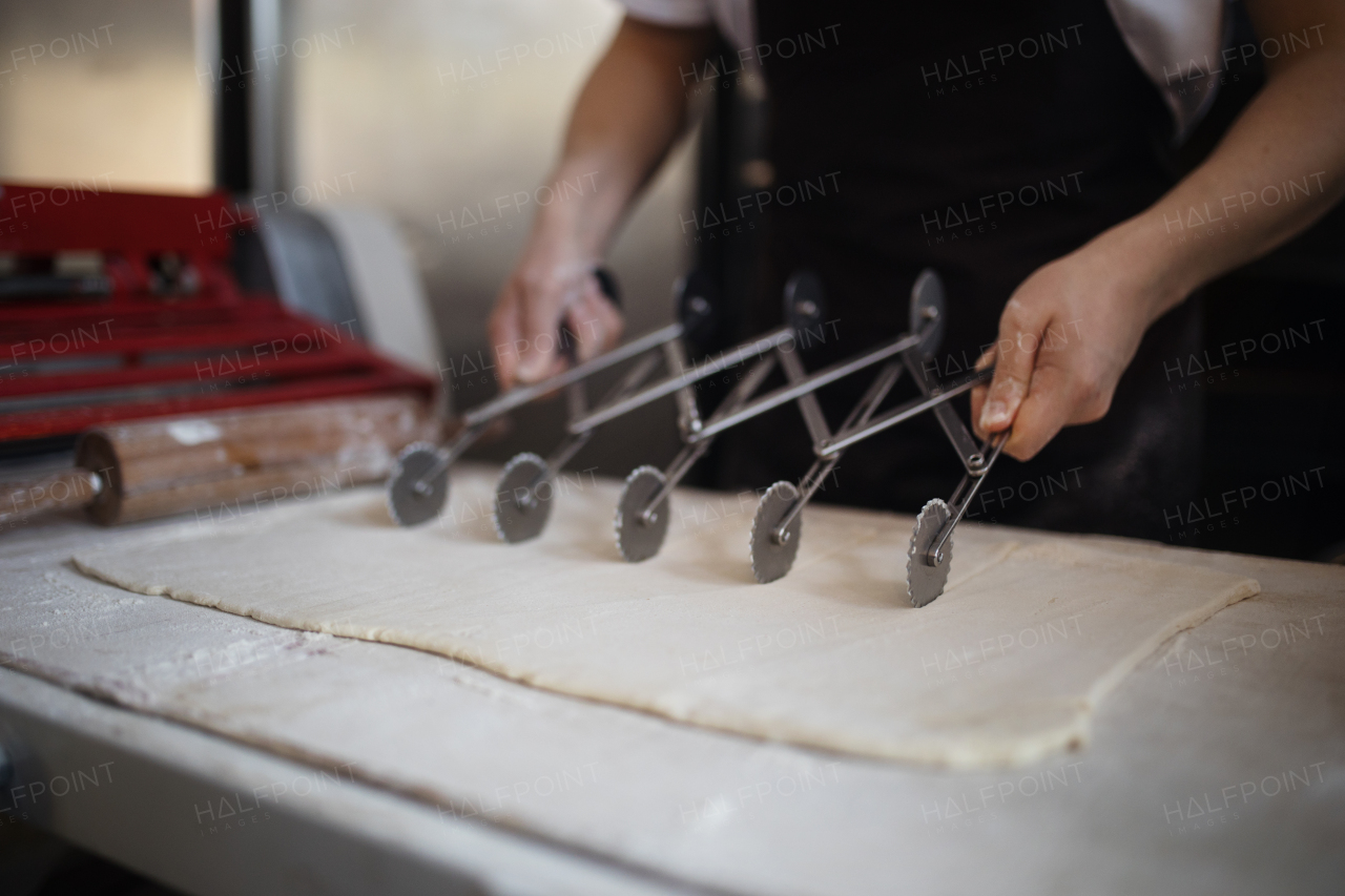 Close-up of baker preparing pastries in a bakery.