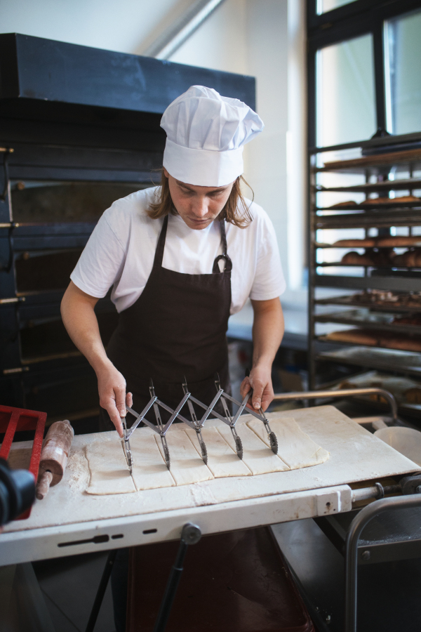 Young baker preparing pastries in a bakery.