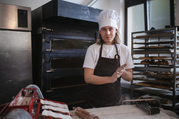 Young baker preparing pastries in a bakery.