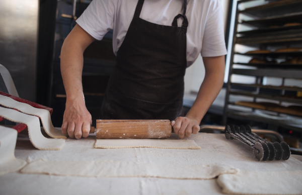 Close-up of baker preparing pastries in a bakery.