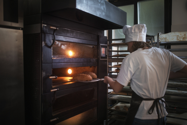 Young baker preparing pastries in a bakery.