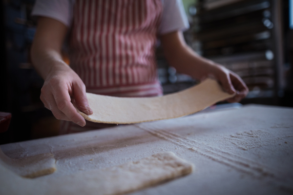 Close-up of baker preparing pastries in a bakery.