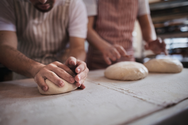 Close-up of bakers preparing fresh pastries in a bakery.