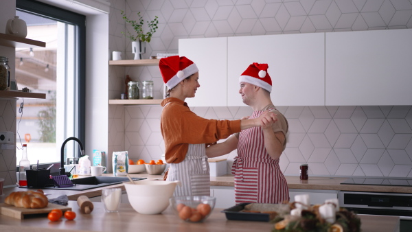 A young man with Down syndrome baking with his mom at home during christmas.