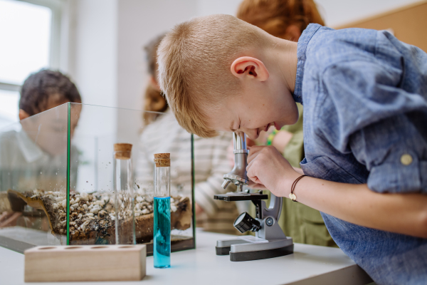 Little boy looking in a microscope during science lesson.