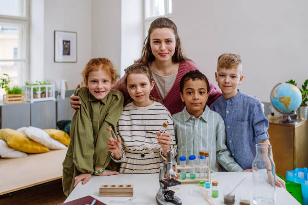 Portrait of young teacher with her pupils during science education.