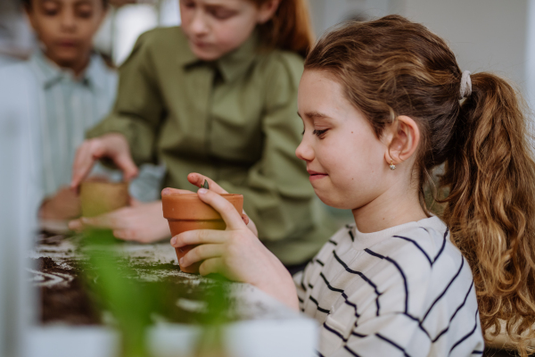 Happy pupils learning how to take care about plants.