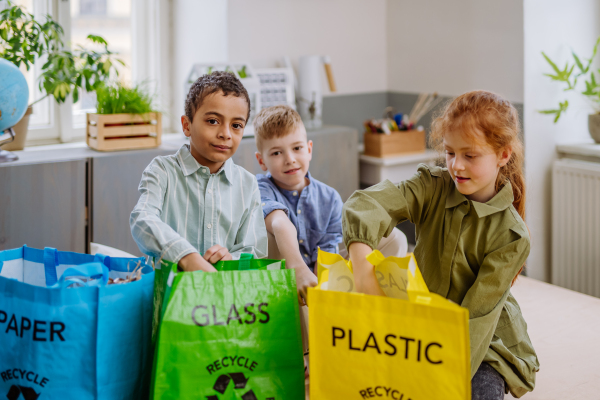 Children separating rubish in to a bins.