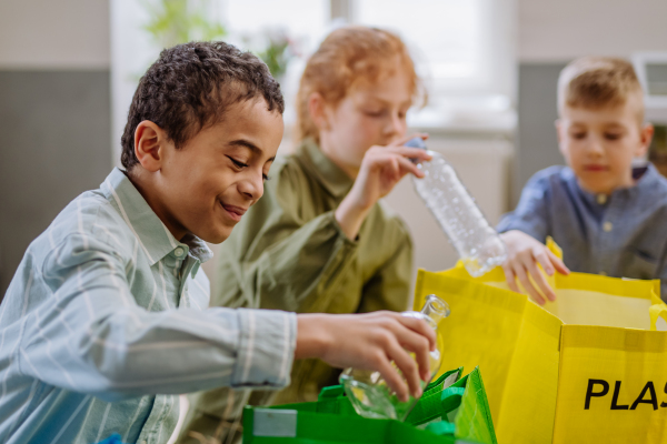 Children separating rubish in to a bins.