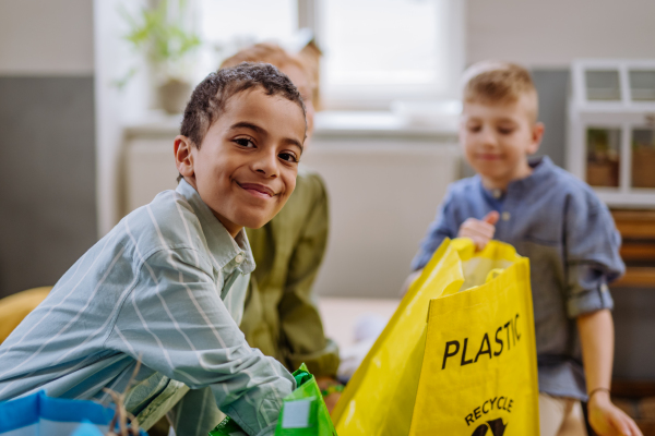 Children separating rubish in to a bins.