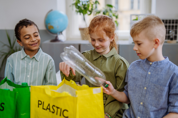 Children separating rubish in to a bins.