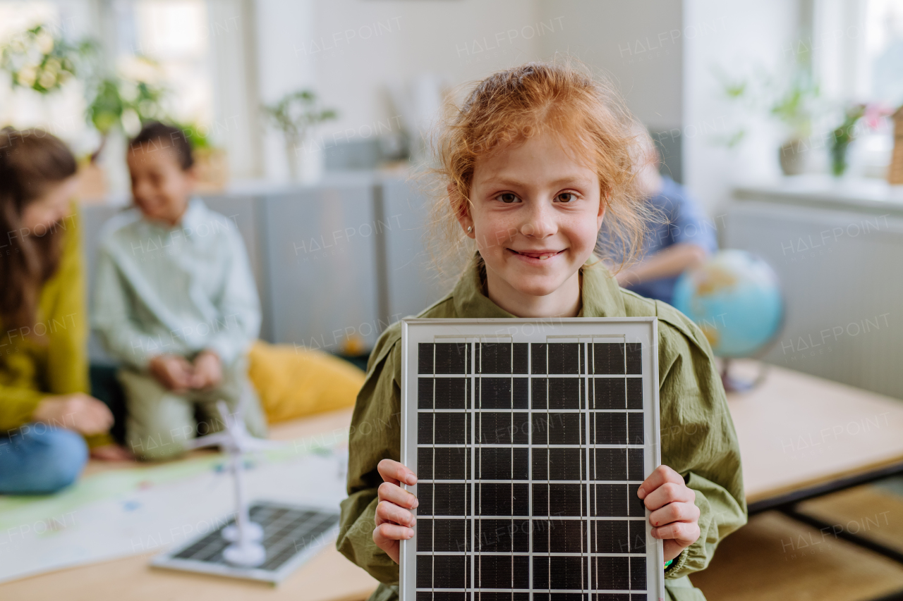 Little girl posing with a solar panel during school lesson.