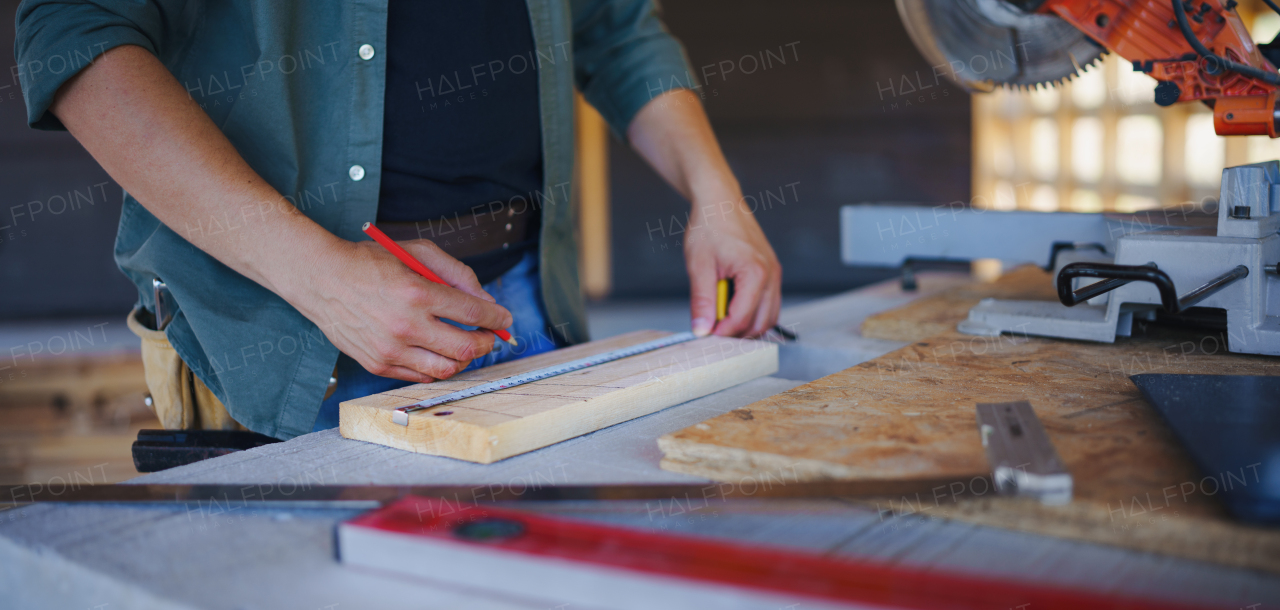 Carpenter measuring wooden planks and making marks with pencil. Carpentry concept.