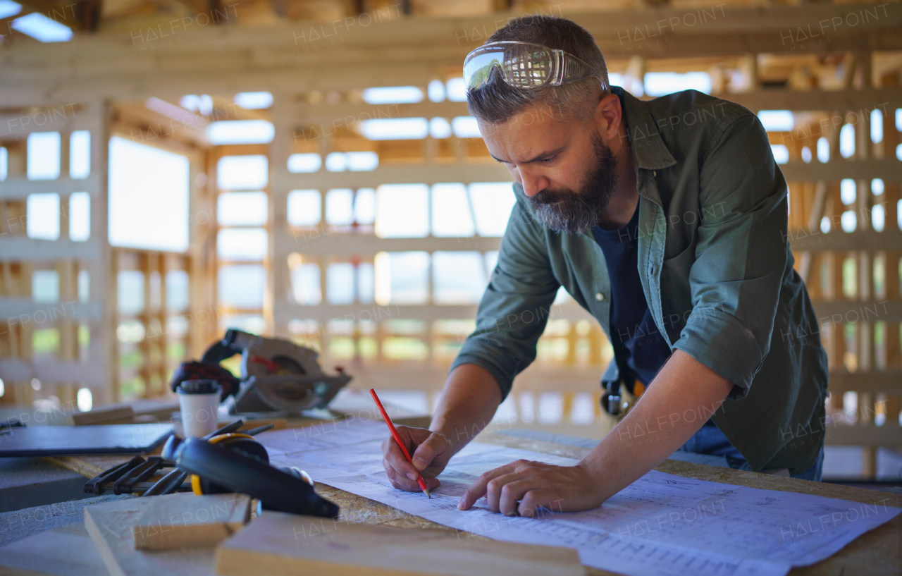 Construction worker drawing and checking a blueprints, diy eco-friendly homes concept.