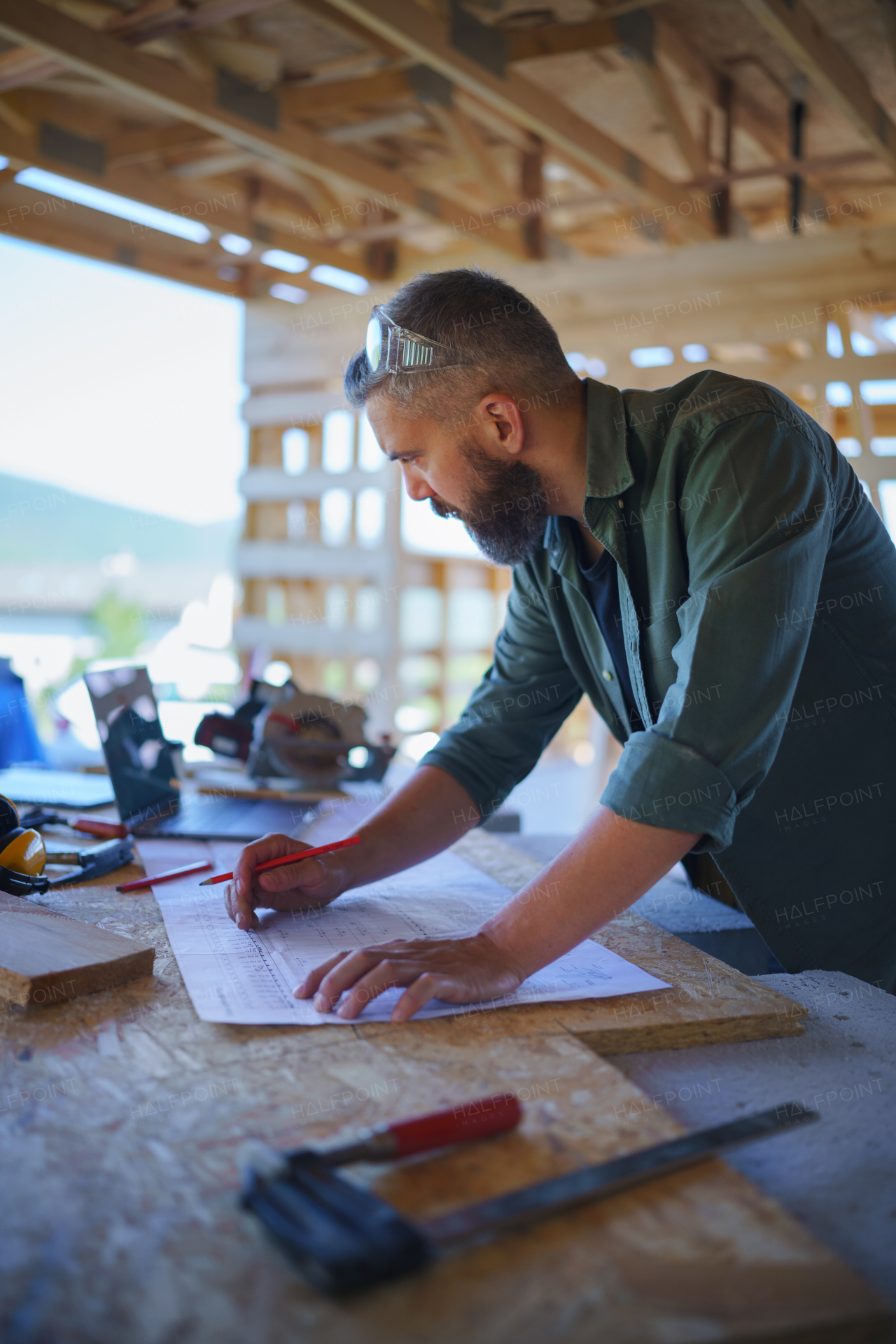 Construction worker smiling, drawing and checking a blueprints, diy eco-friendly homes concept.