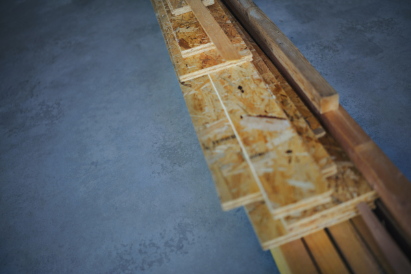 Top view of construction wooden boards at a concrete floor, concept of eco house, healthy living and green architecture.