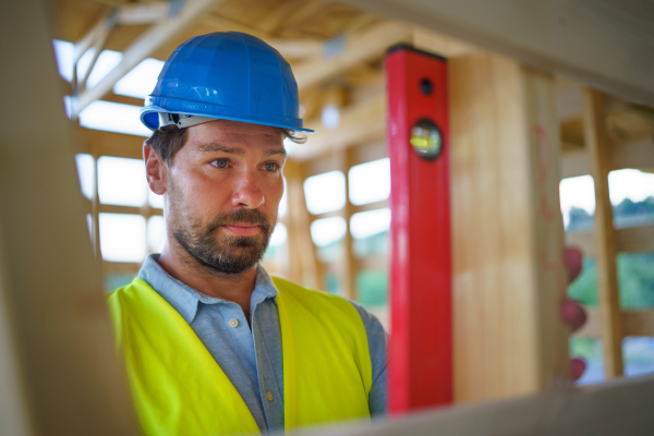 Carpenter checking a wooden planks with spirit level, diy eco-friendly homes concept.