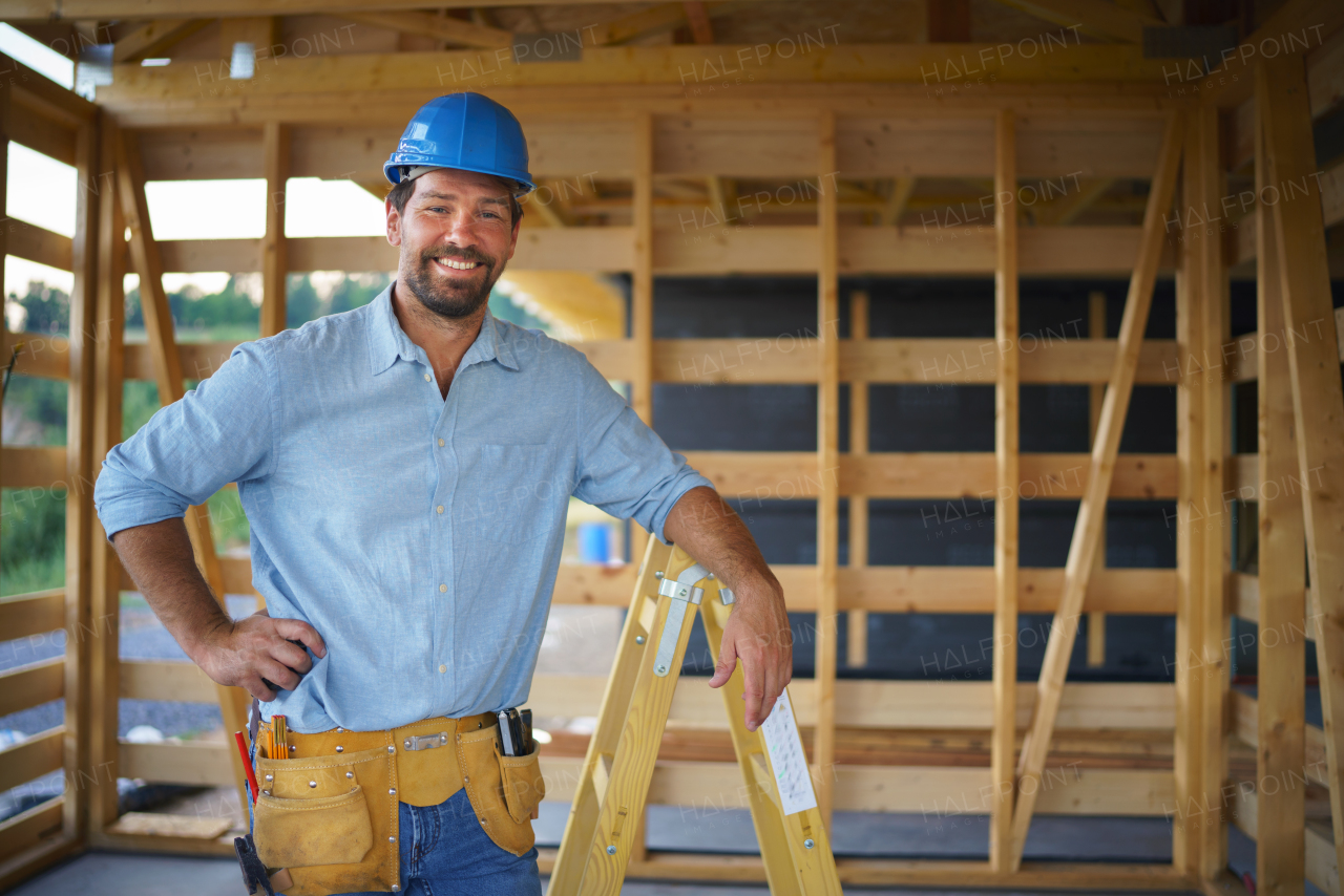 A portrait of construction worker smiling and looking at camera, diy eco-friendly homes concept.